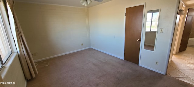 carpeted spare room with ceiling fan