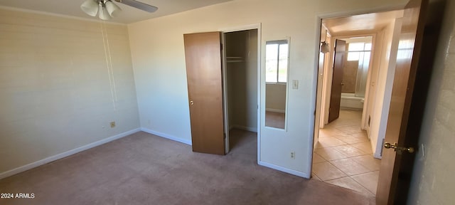 unfurnished bedroom with ceiling fan, a closet, and light tile patterned floors