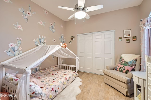 bedroom with a closet, a ceiling fan, and light wood-style flooring