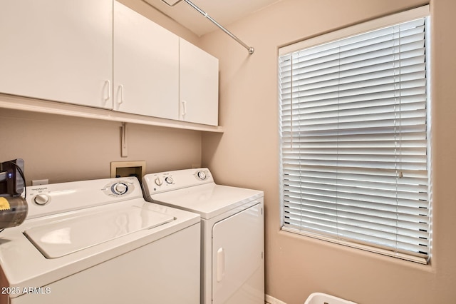 laundry area with independent washer and dryer and cabinet space