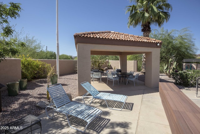 view of patio / terrace with a gazebo, a fenced backyard, and outdoor dining area