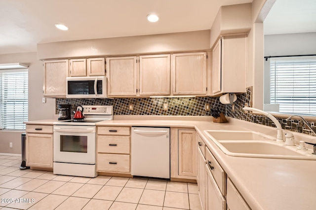 kitchen with light brown cabinetry, white appliances, light countertops, a sink, and light tile patterned floors
