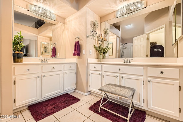full bath featuring vanity, tile patterned floors, baseboards, and a stall shower