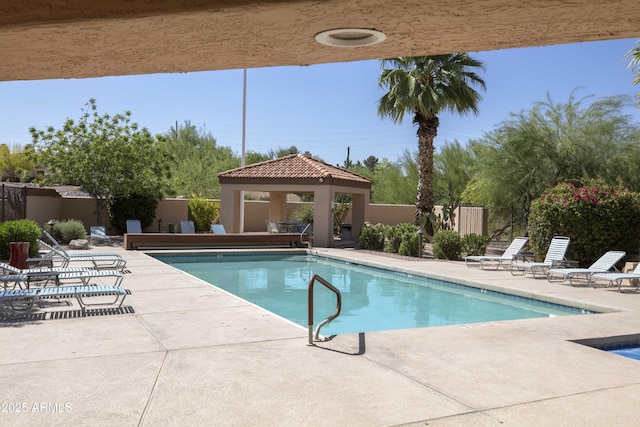 pool featuring a gazebo, a patio area, and fence