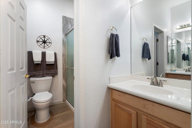 bathroom featuring a shower with door, wood-type flooring, vanity, and toilet