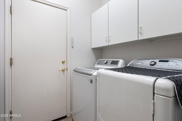 laundry area with cabinets and washing machine and clothes dryer