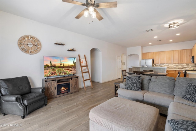 living room featuring ceiling fan and light wood-type flooring