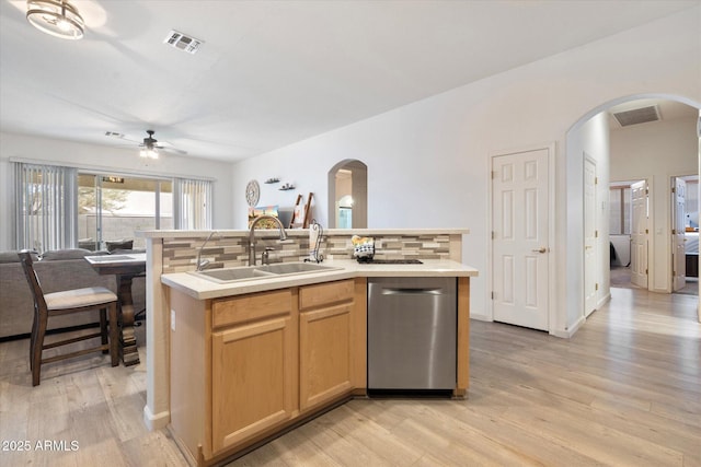 kitchen with a kitchen island with sink, sink, decorative backsplash, and stainless steel dishwasher