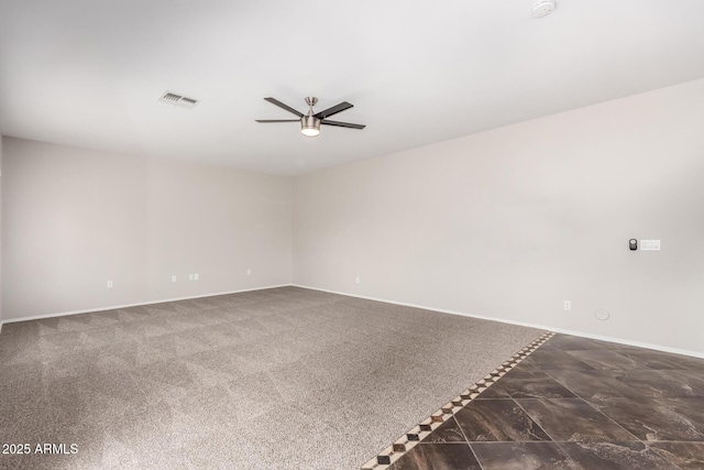 spare room with baseboards, visible vents, carpet floors, and ceiling fan