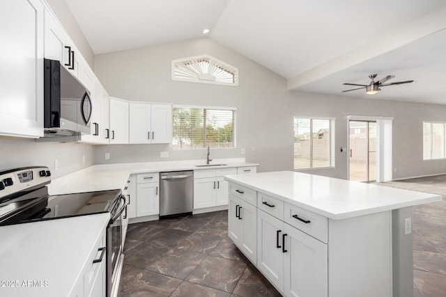 kitchen with plenty of natural light, white cabinetry, stainless steel appliances, and lofted ceiling