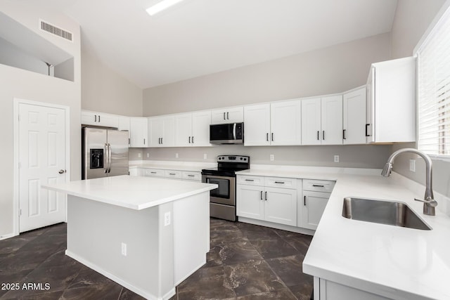 kitchen with visible vents, a center island, light countertops, appliances with stainless steel finishes, and a sink