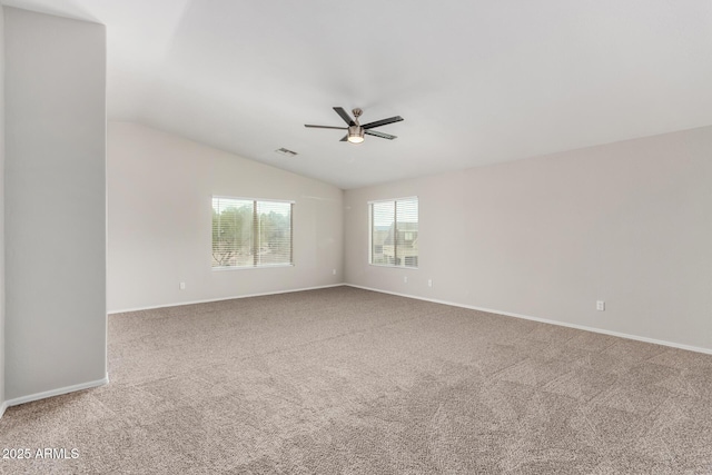 carpeted empty room featuring visible vents, lofted ceiling, baseboards, and a ceiling fan