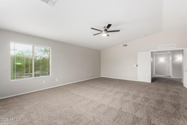 empty room with visible vents, carpet floors, a ceiling fan, and vaulted ceiling