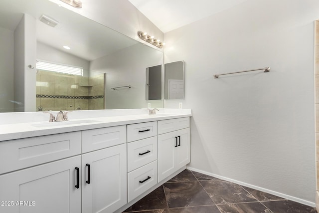 bathroom with visible vents, a sink, double vanity, tiled shower, and vaulted ceiling