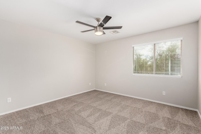 carpeted empty room with baseboards, visible vents, and ceiling fan