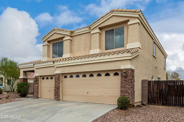 view of front facade featuring stucco siding, driveway, stone siding, fence, and a garage