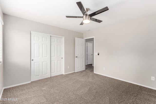 unfurnished bedroom featuring a closet, baseboards, carpet, and ceiling fan