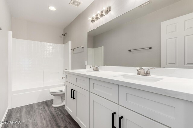 full bathroom with toilet, visible vents, and a sink