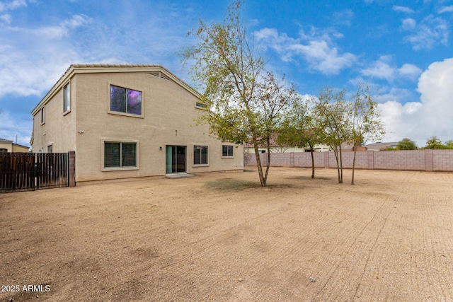 back of property featuring stucco siding, a fenced backyard, and a tile roof