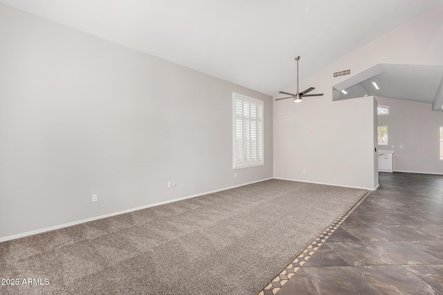 spare room featuring visible vents, high vaulted ceiling, a ceiling fan, dark colored carpet, and baseboards