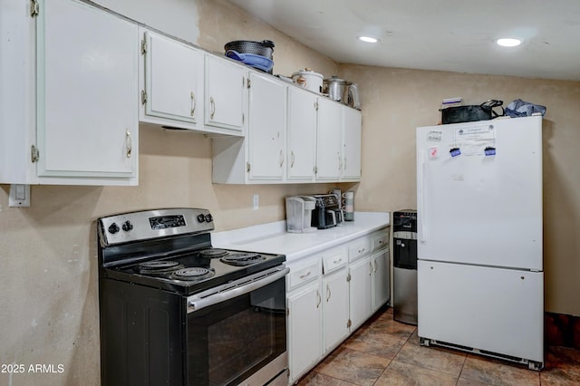 kitchen featuring white refrigerator, white cabinets, and stainless steel range with electric stovetop