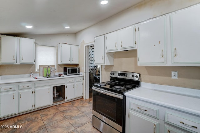 kitchen featuring white cabinetry, sink, vaulted ceiling, and appliances with stainless steel finishes