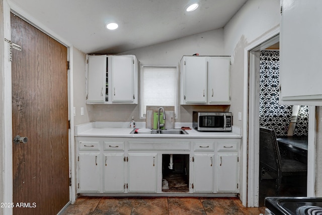 kitchen with vaulted ceiling, sink, and white cabinets