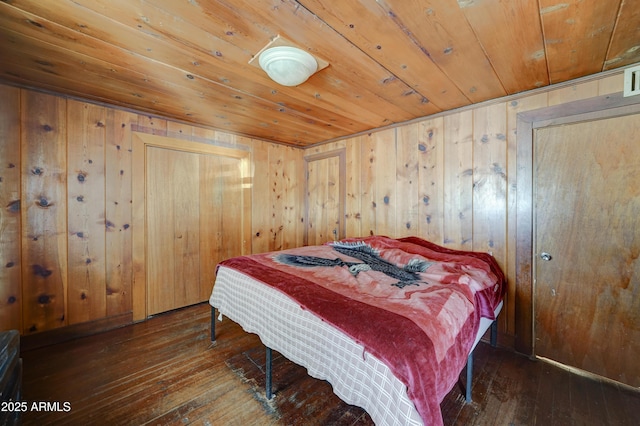 bedroom with wood ceiling, dark wood-type flooring, and wood walls