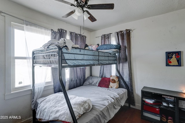 bedroom featuring ceiling fan, dark hardwood / wood-style floors, and a textured ceiling