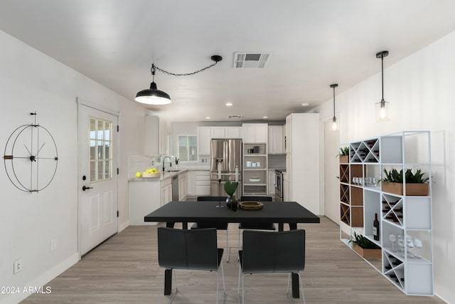 dining area featuring sink and light wood-type flooring