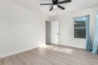 empty room with ceiling fan and wood-type flooring