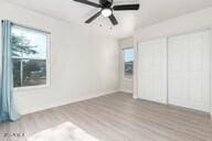 unfurnished bedroom with ceiling fan and hardwood / wood-style flooring