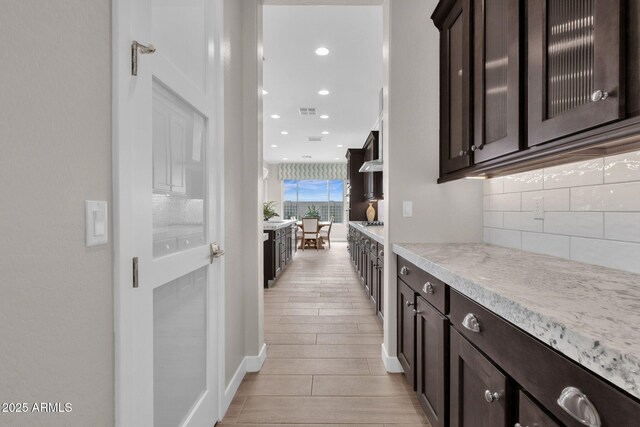 hall featuring light wood-style floors, recessed lighting, and visible vents