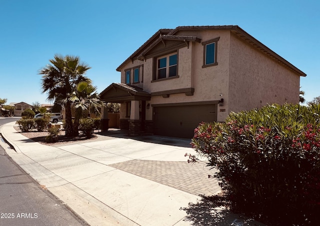 view of front of house with a garage, stucco siding, and decorative driveway