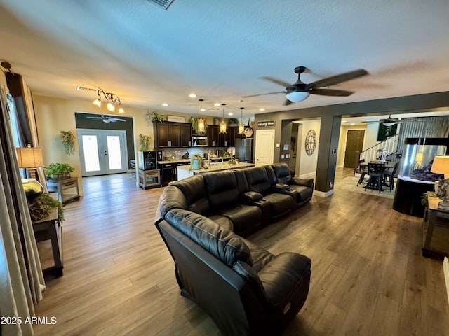 living room featuring ceiling fan, recessed lighting, light wood finished floors, and baseboards