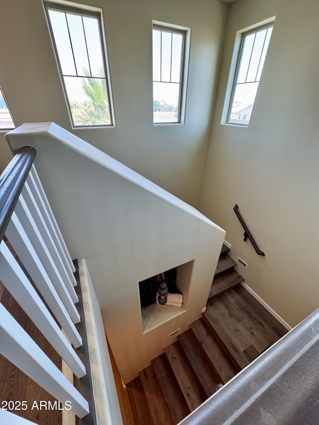 stairway featuring wood finished floors and baseboards