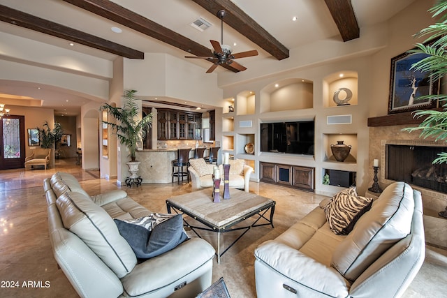 living room with beam ceiling, a high end fireplace, ceiling fan, and a towering ceiling