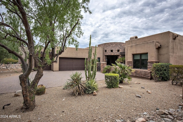 pueblo revival-style home featuring a garage