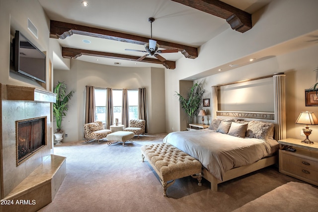 bedroom with beamed ceiling, carpet, a fireplace, and ceiling fan