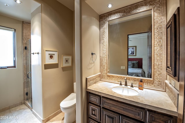 bathroom with a shower with door, vanity, backsplash, and toilet