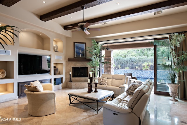 living room with beam ceiling, a fireplace, built in features, and ceiling fan