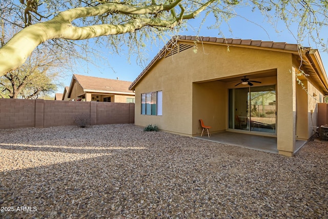 rear view of property featuring ceiling fan and a patio area