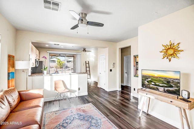 living room with ceiling fan and dark hardwood / wood-style floors