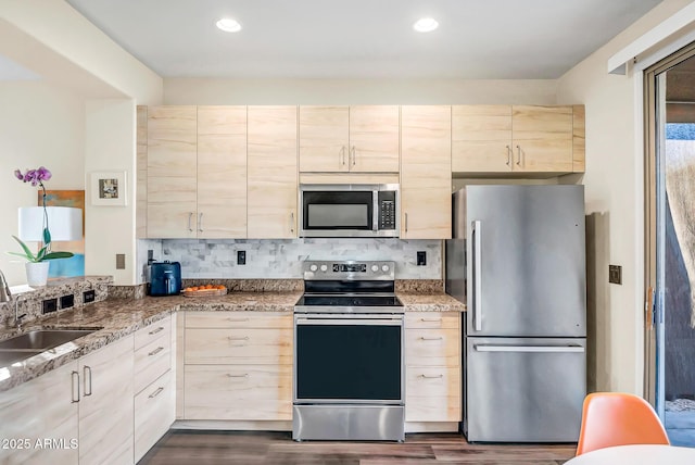 kitchen with sink, stone counters, stainless steel appliances, tasteful backsplash, and dark hardwood / wood-style flooring