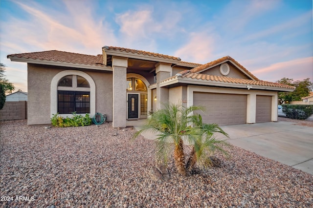 mediterranean / spanish-style home with a garage