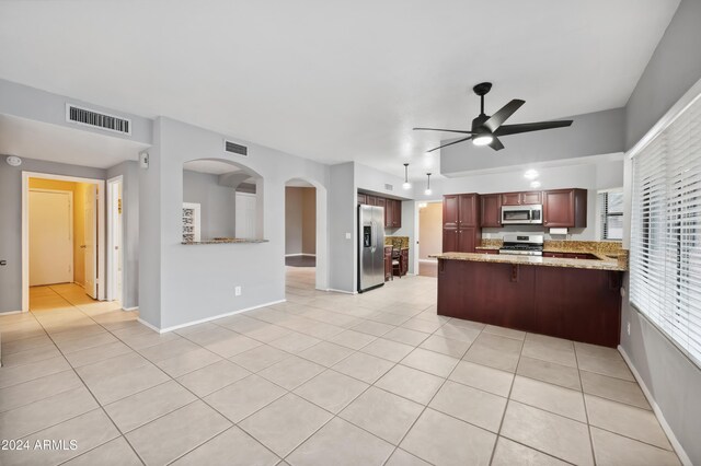 kitchen featuring kitchen peninsula, ceiling fan, light tile patterned flooring, and appliances with stainless steel finishes