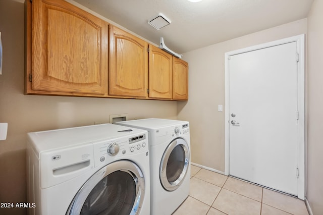 laundry room with cabinets, light tile patterned floors, and separate washer and dryer