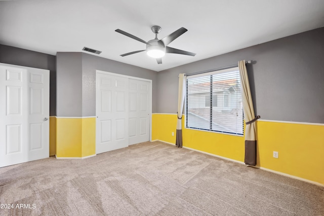 unfurnished bedroom featuring ceiling fan, a closet, and carpet