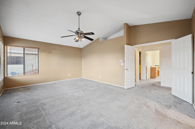 unfurnished room featuring ceiling fan, light colored carpet, and vaulted ceiling