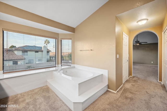 bathroom with a tub to relax in, ceiling fan, and lofted ceiling